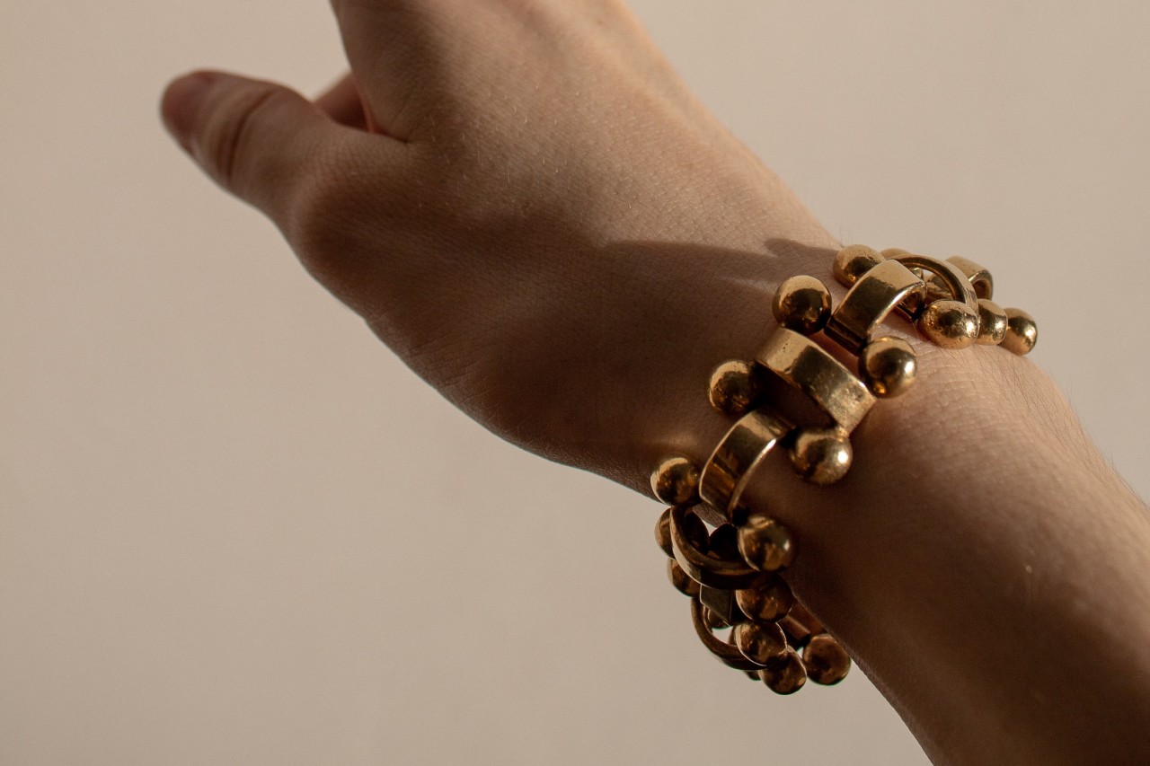 A woman wearing a gold elastic bracelet from Roberto Demeglio. A woman wearing a gold elastic bracelet from Roberto Demeglio.